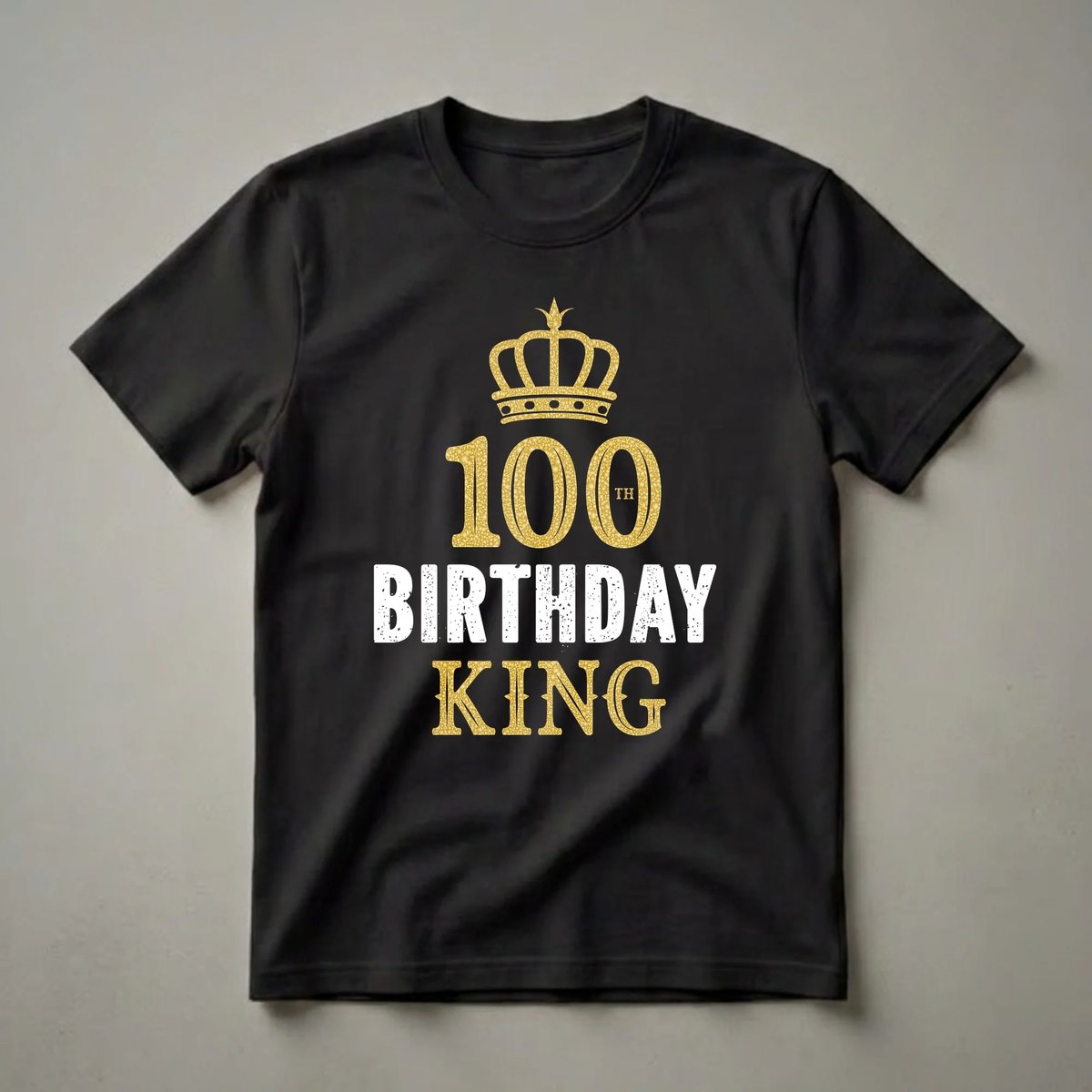 Black t-shirt with a gold crown graphic above the number '100' and the text 'TH BIRTHDAY KING' in distressed white and gold.