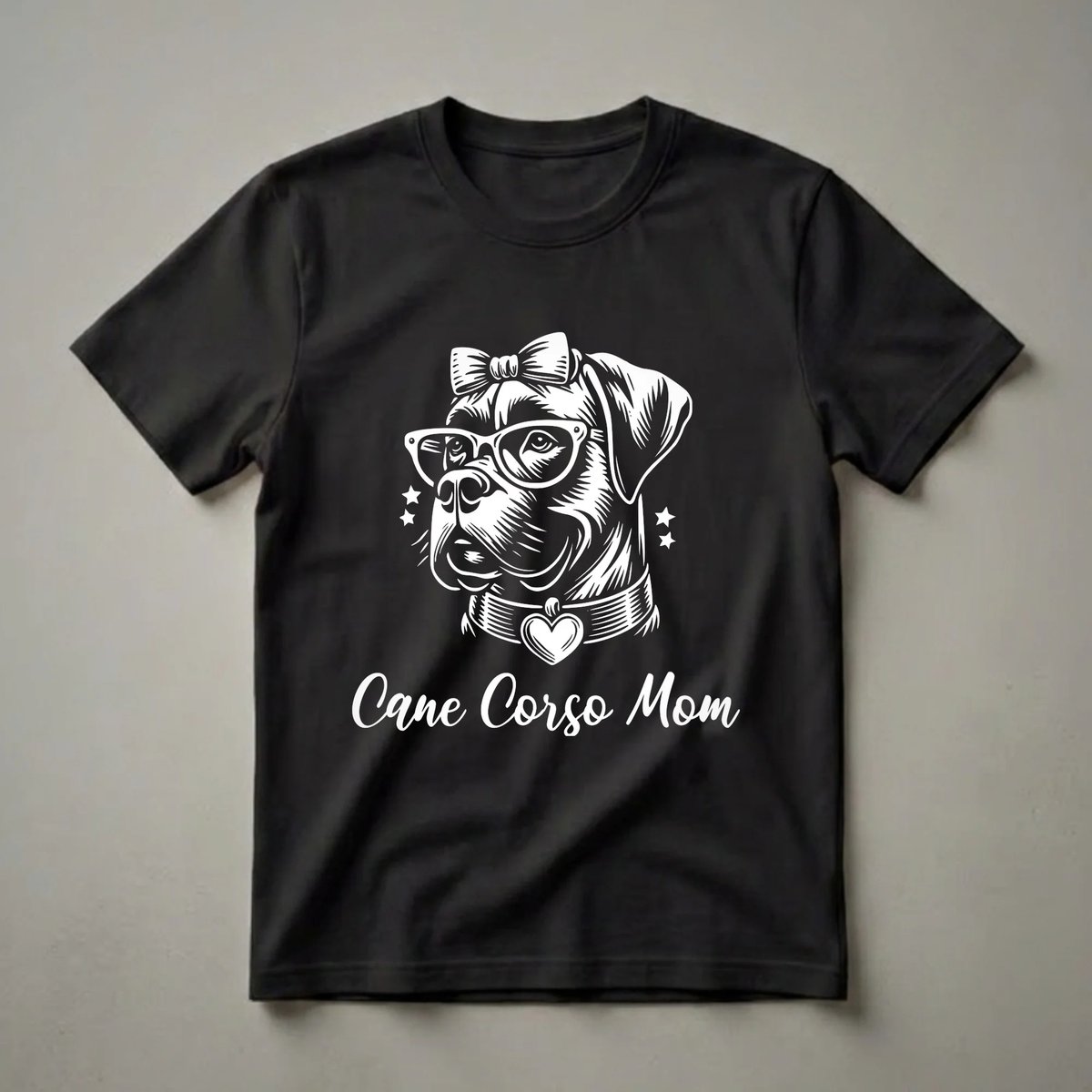 Black t-shirt featuring a white graphic of a Cane Corso dog wearing glasses and a bow, with a heart pendant on its collar, and the text 'Cane Corso Mom'.