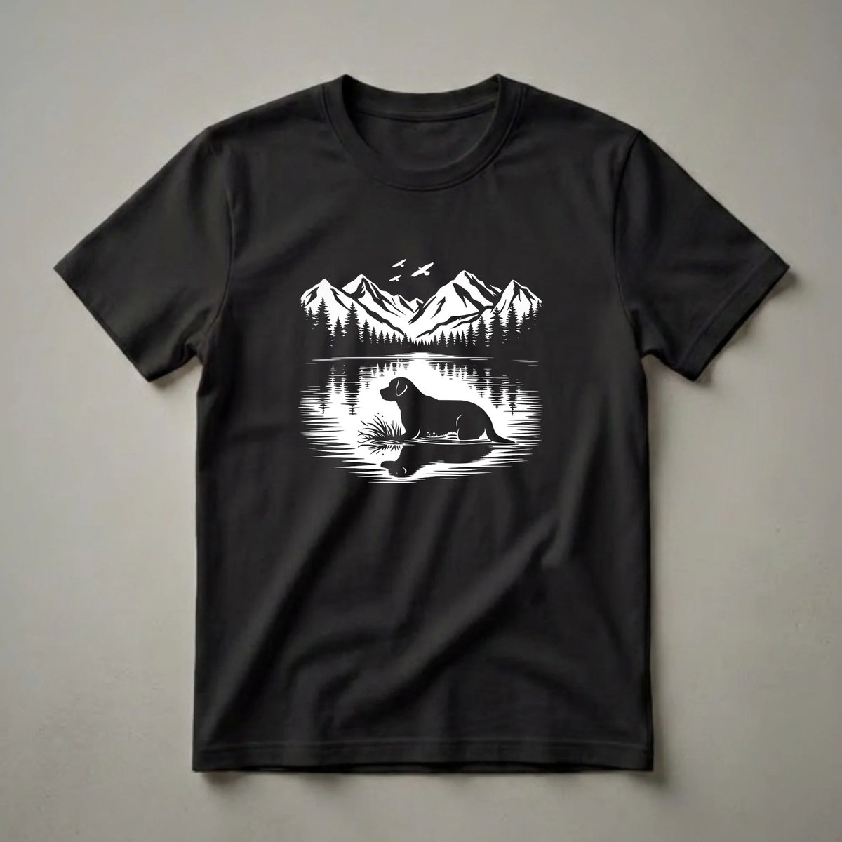Black graphic t-shirt featuring a silhouette of a Labrador Retriever in a lake with pine trees and mountains in the background, and birds flying overhead.