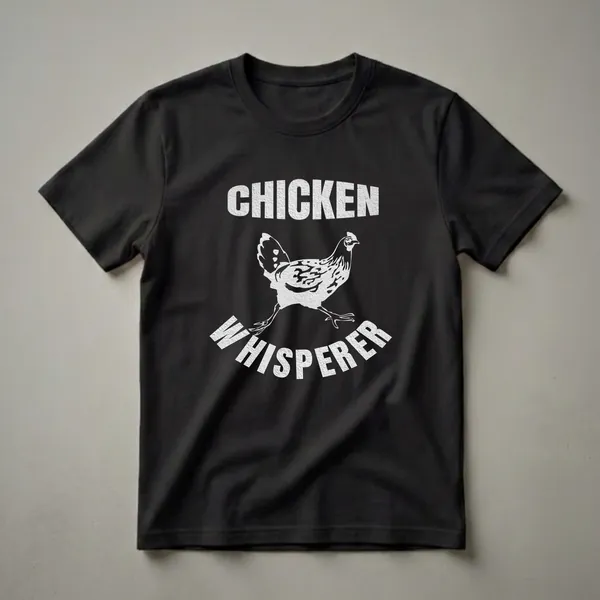 Black t-shirt with a white graphic of a chicken walking, with the words "CHICKEN" above and "WHISPERER" below.