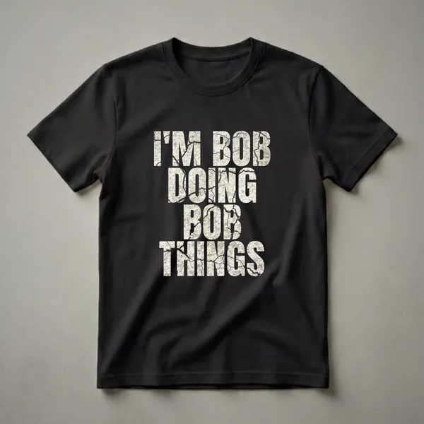 Black t-shirt with white distressed text that reads 'I'M BOB DOING BOB THINGS', featuring a cracked texture.
