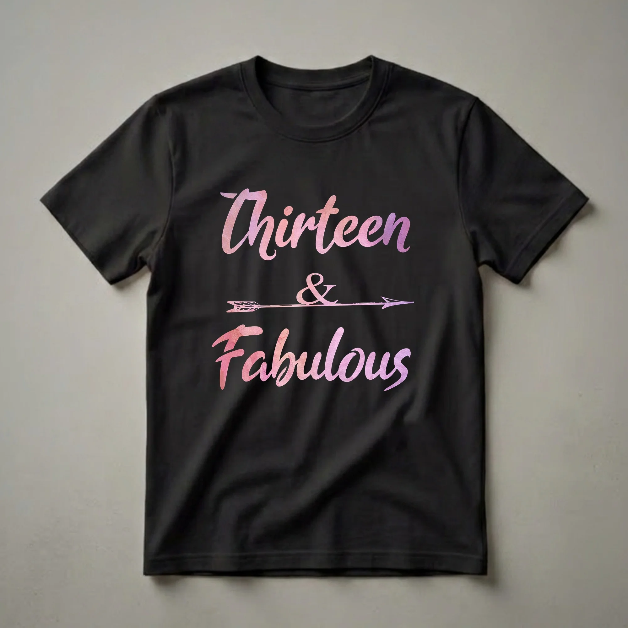Black graphic t-shirt featuring the words "Thirteen & Fabulous" in a pink and purple watercolor font, with an arrow graphic in the center.