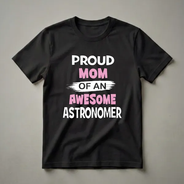 Black t-shirt with bold white and pink text that reads 'Proud Mom Of An Astronomer', featuring a distressed brush stroke effect behind 'OF AN'.