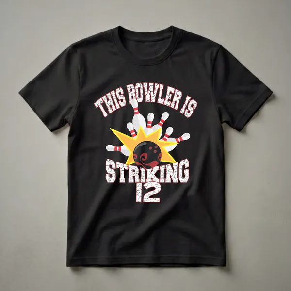 Black t-shirt with white and red distressed text that reads 'THIS BOWLER IS STRIKING 12', featuring a graphic of a bowling ball hitting pins with a yellow starburst.