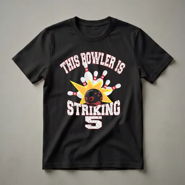 Black graphic t-shirt with white distressed text 'THIS BOWLER IS STRIKING' and a large cracked white number '5', featuring a bowling ball hitting white pins on a yellow starburst.