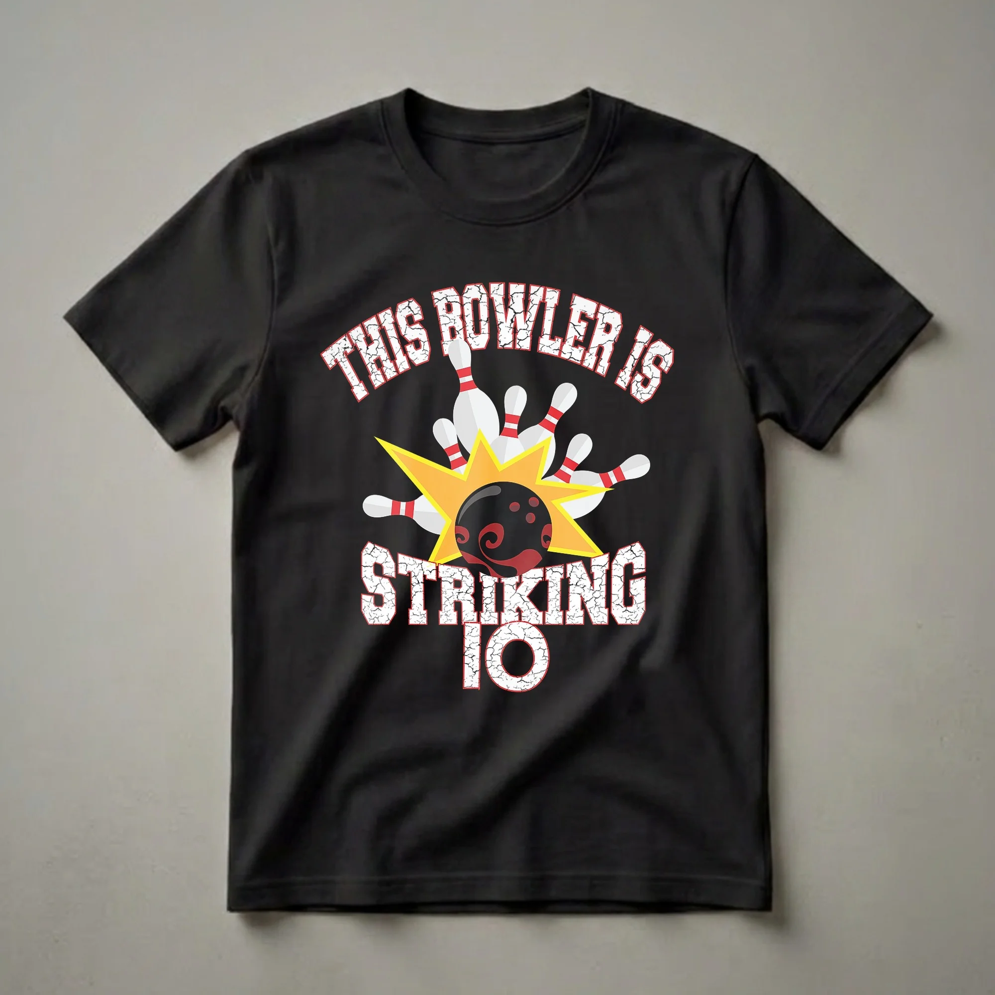 Black t-shirt with white and red text reading 'This Bowler Is Striking 10', featuring a bowling ball, pins, and a yellow starburst graphic.
