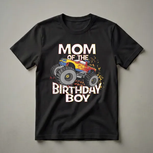 Black t-shirt with white and yellow text 'MOM OF THE BIRTHDAY BOY' and a red, yellow, and blue monster truck with flames.