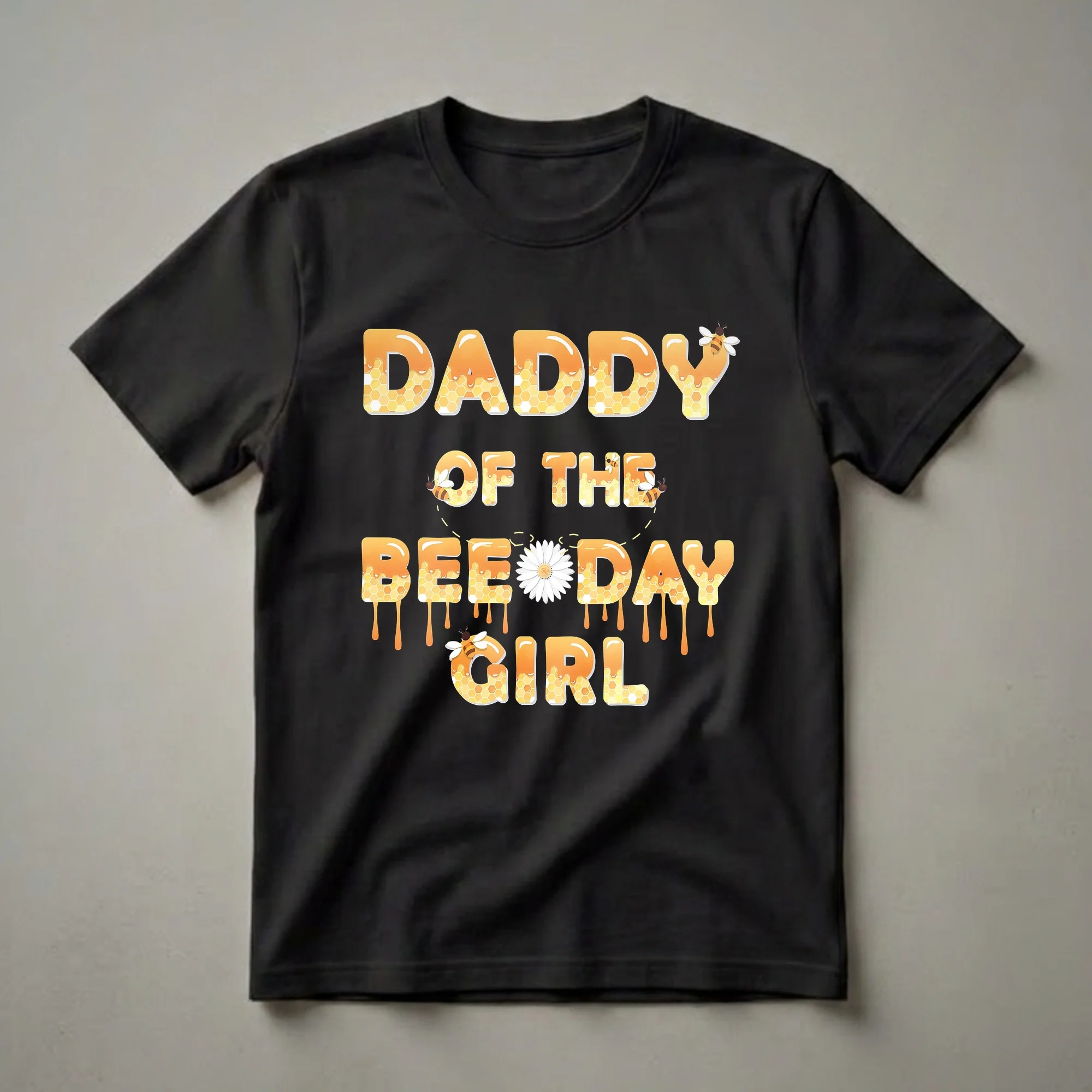 Black t-shirt with the words 'Daddy Of The Bee Day Girl' in large, bubbly letters filled with honeycomb patterns and dripping honey, accented by bees and a daisy.