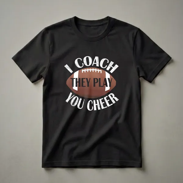 Black t-shirt with distressed white text that reads 'I COACH THEY PLAY YOU CHEER' surrounding a brown football illustration.