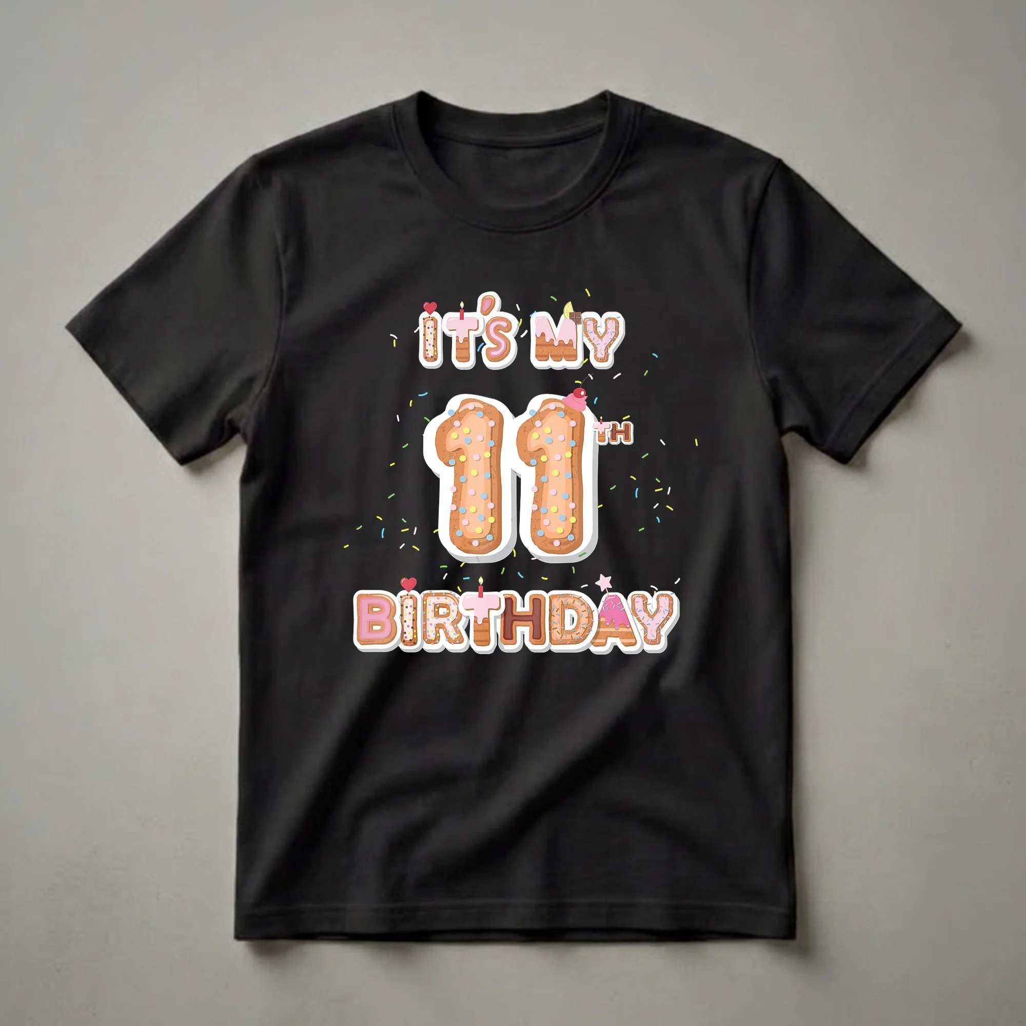 Black t-shirt featuring a "It's My 11th Birthday" graphic with donut-themed letters, the number 11, and colorful sprinkles.