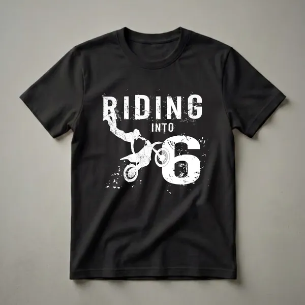 Black t-shirt with a white graphic that reads 'RIDING INTO 6' featuring a silhouette of a dirt bike rider mid-air and distressed paint splatters.