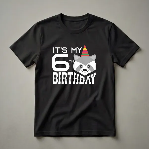White graphic t-shirt with black background featuring the text 'IT'S MY 6TH BIRTHDAY' and a cartoon raccoon wearing a colorful party hat.