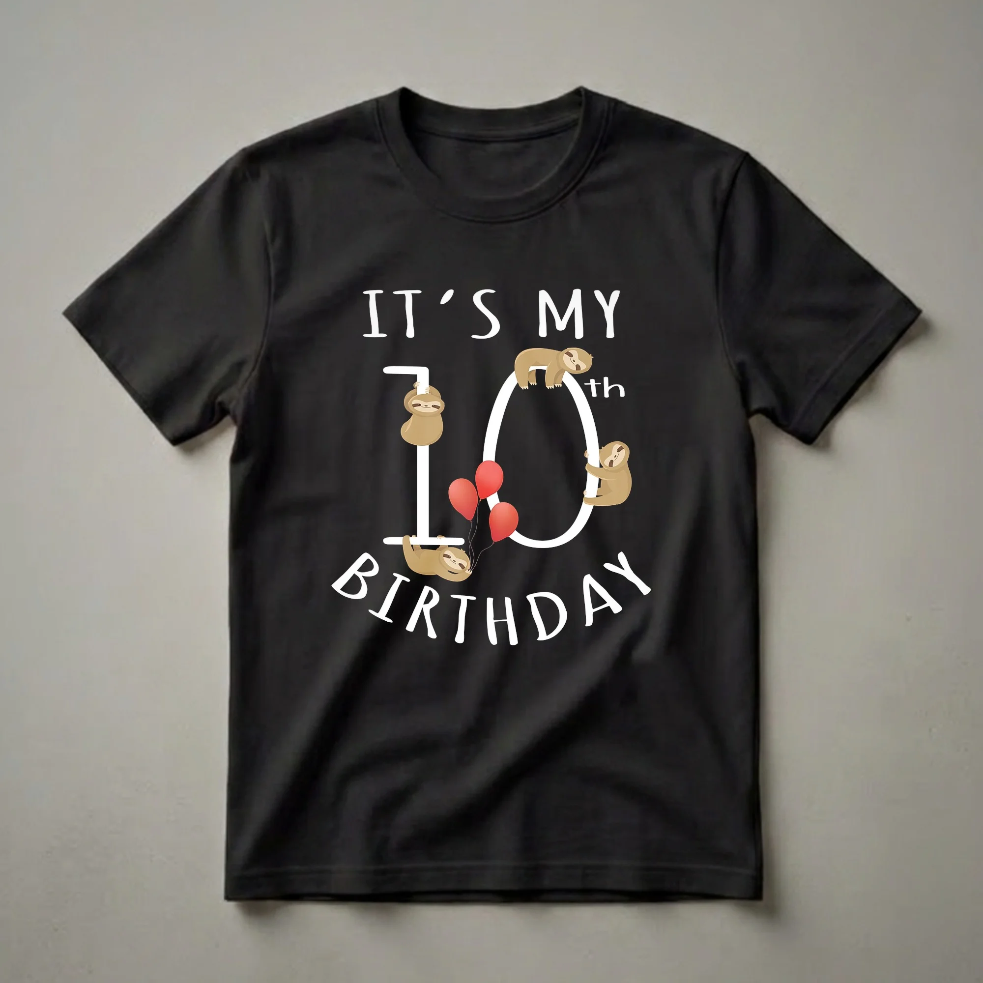 Black t-shirt with white text "IT'S MY BIRTHDAY" and a large white number 10, adorned with four cartoon sloths and three red balloons.
