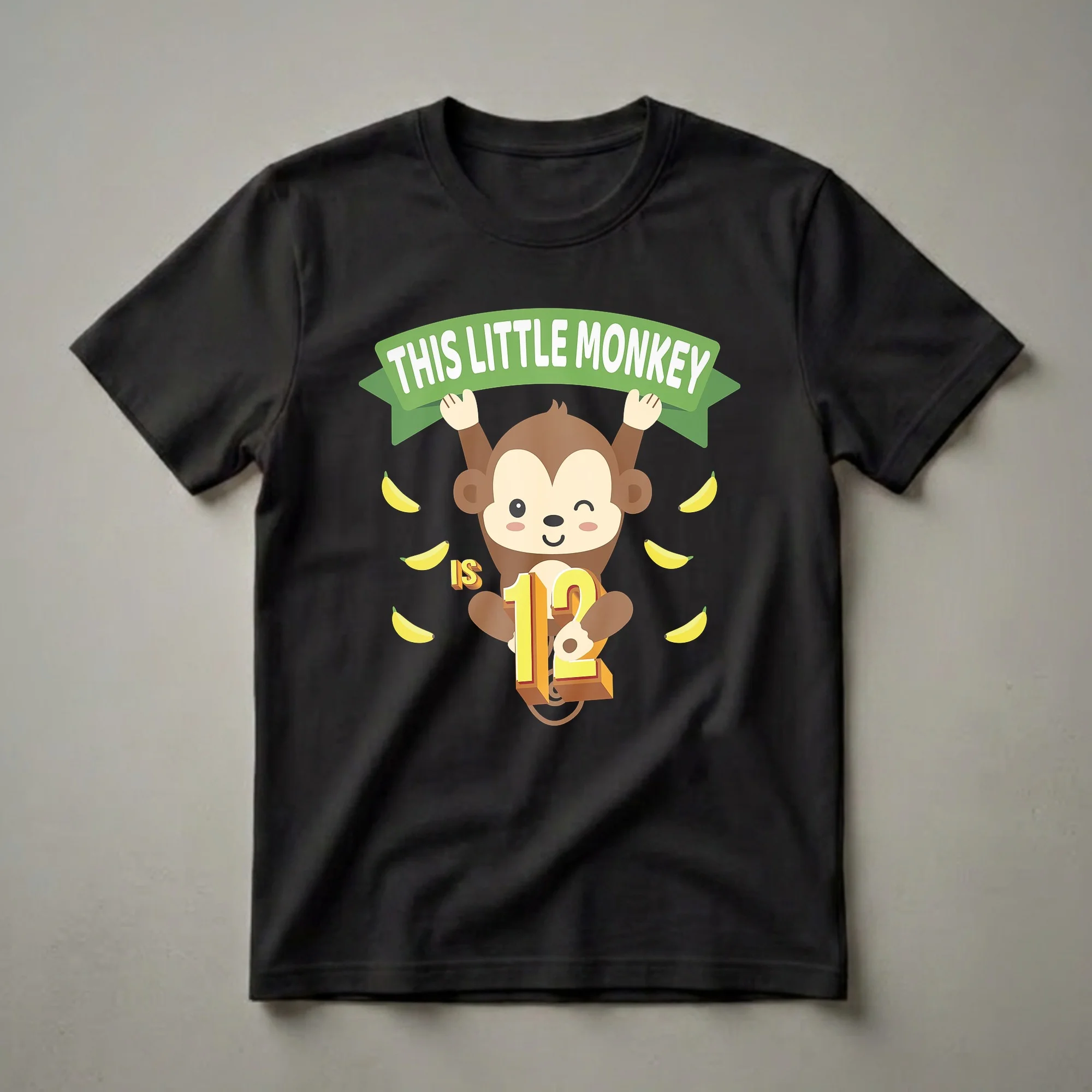 A black t-shirt featuring a cartoon monkey hanging from a green banner that reads 'THIS LITTLE MONKEY', with bananas scattered around and the number '12' prominently displayed.