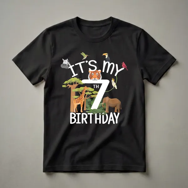 Black t-shirt with white text 'IT'S MY 7TH BIRTHDAY' surrounded by cartoon zoo animals including a tiger, giraffe, elephant, crocodile, zebra, toucan, cockatoo, cardinal, and hummingbird.