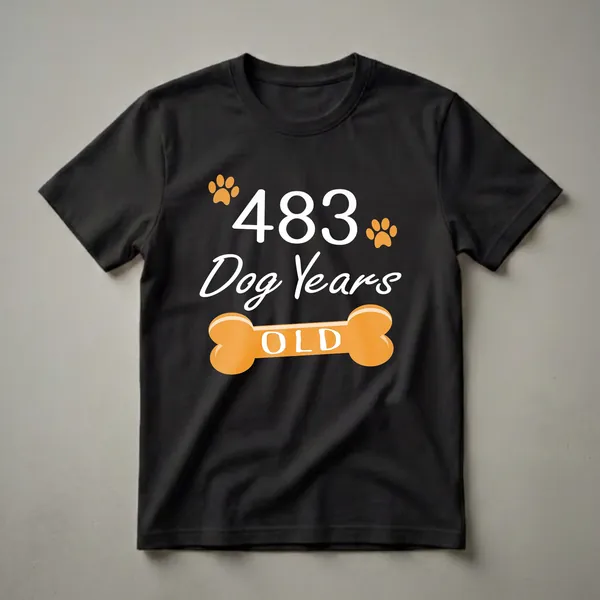 Black t-shirt with white text reading '483 Dog Years Old' and orange paw prints and a dog bone graphic.
