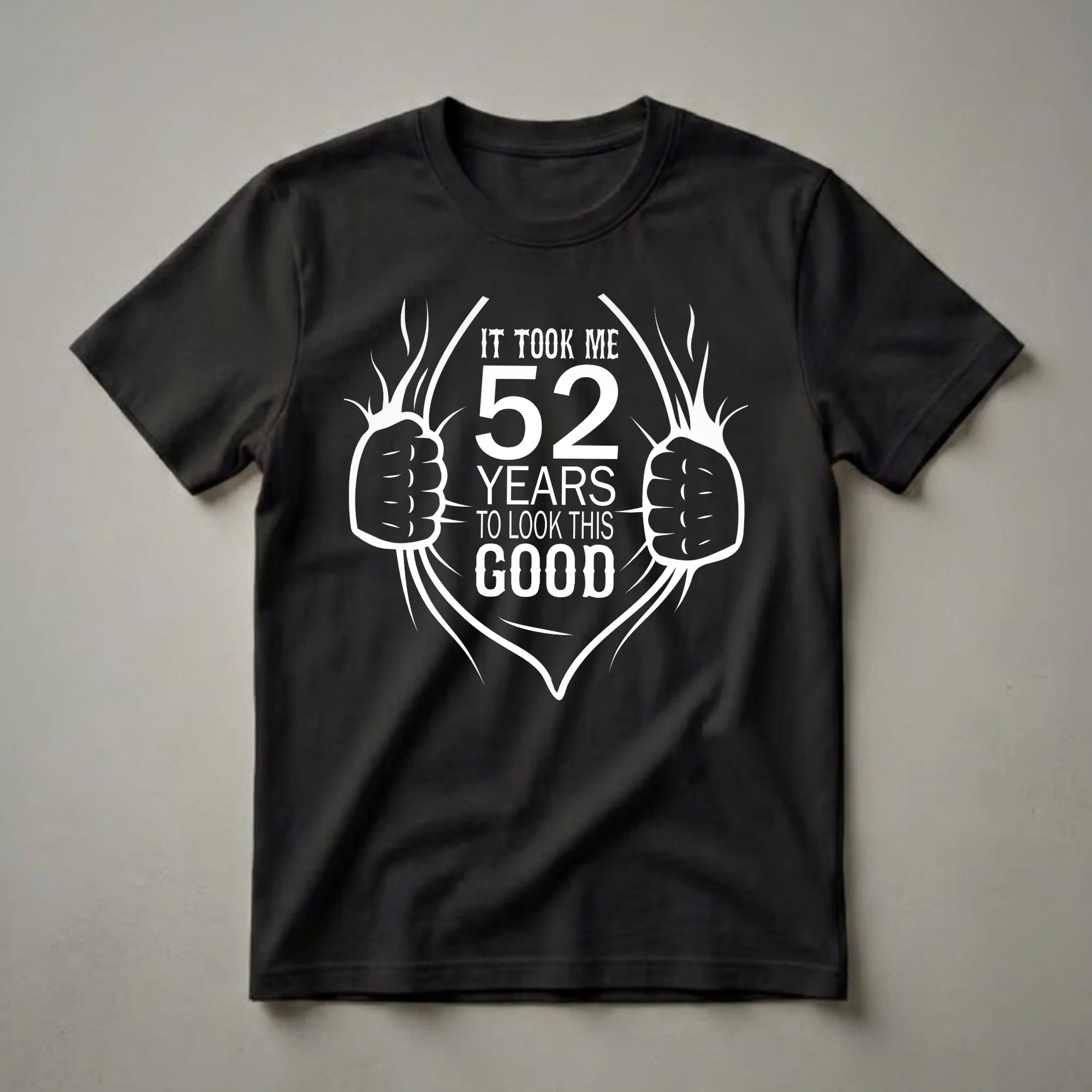 Black t-shirt with white graphic text that reads 'IT TOOK ME 52 YEARS TO LOOK THIS GOOD' with stylized hands ripping open the shirt to reveal the number 52.