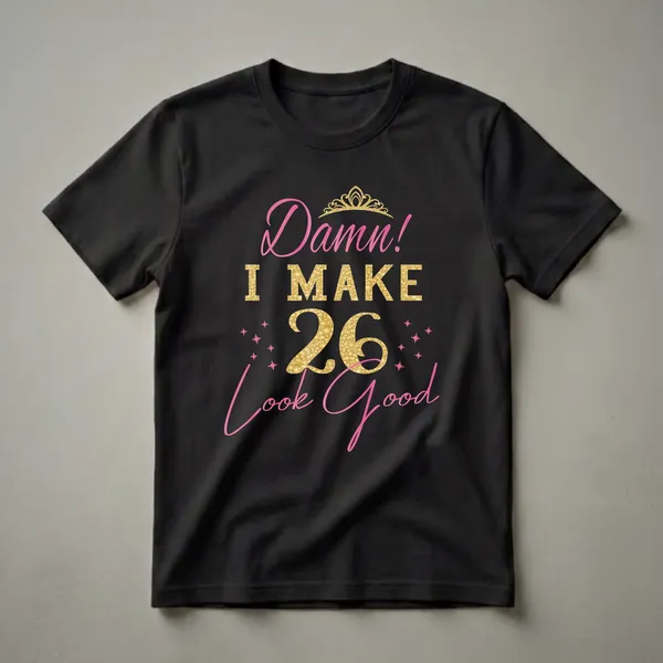 Black t-shirt with pink and gold text that reads 'Damn! I Make 26 Look Good', featuring a golden crown and pink stars.