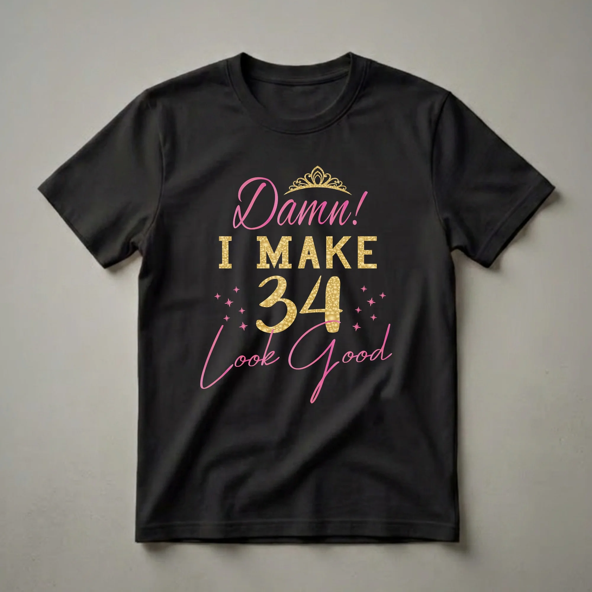 Black t-shirt with pink and gold text that reads 'Damn! I MAKE 34 Look Good', featuring a golden crown and pink stars.