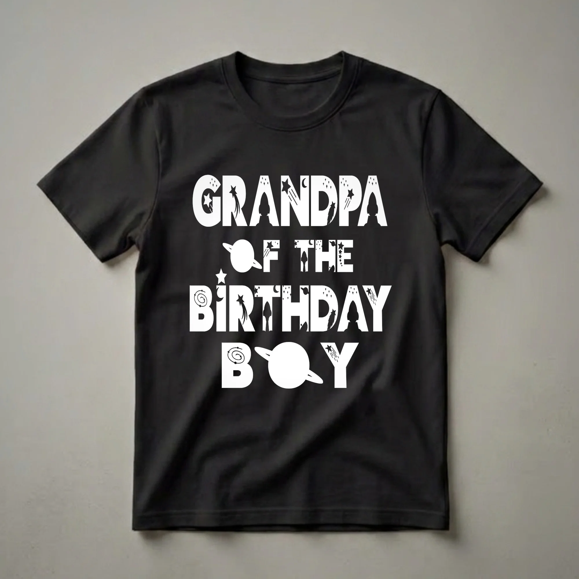 Black t-shirt with white text reading 'GRANDPA OF THE BIRTHDAY BOY' decorated with space elements like rockets, stars, planets, and moons.