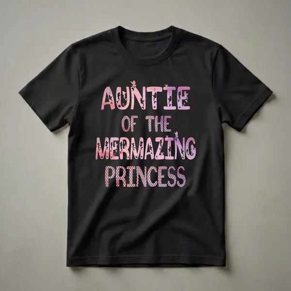 A black t-shirt with the text 'Auntie Of The Mermazing Princess' in watercolor fill and mermaid silhouette embellishments.