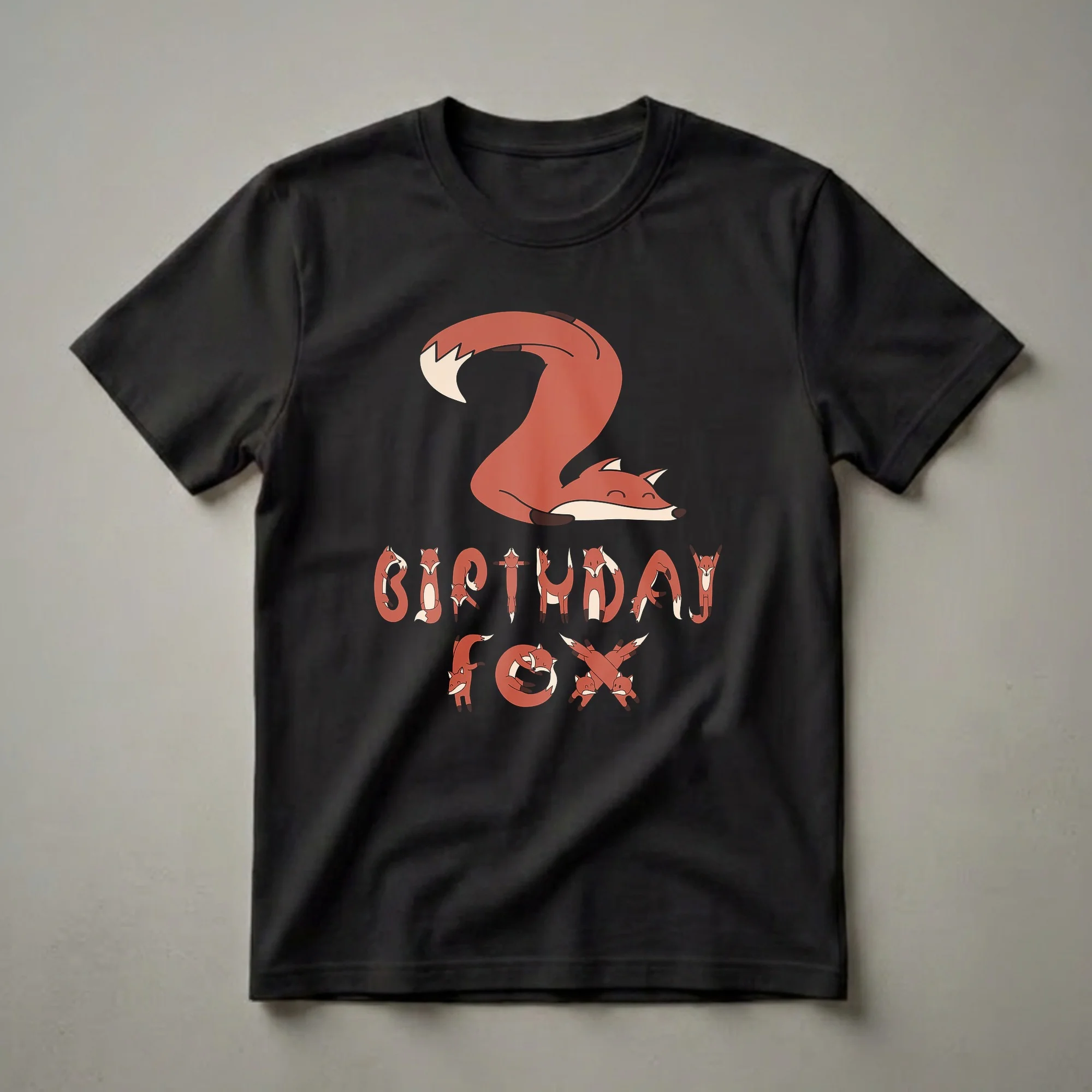 A black t-shirt featuring a graphic design with a large number '2' made from a sleeping fox and the words 'BIRTHDAY FOX' spelled out by smaller foxes.