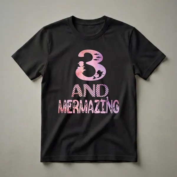 Black t-shirt with a pink and purple watercolor design featuring the number 3, mermaids, fish, and the text 'AND MERMAZING' with ocean elements.