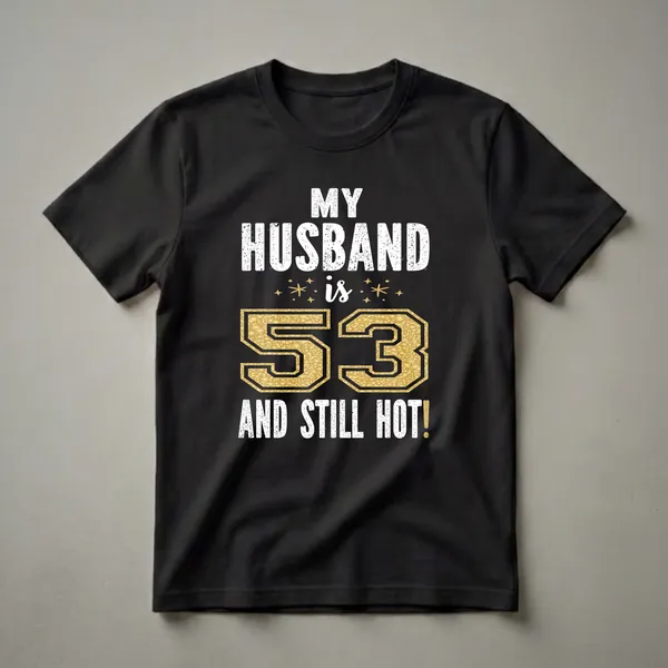 Black t-shirt with white distressed text reading 'MY HUSBAND IS' and 'AND STILL HOT!', with a large gold glitter number '53' in the center.
