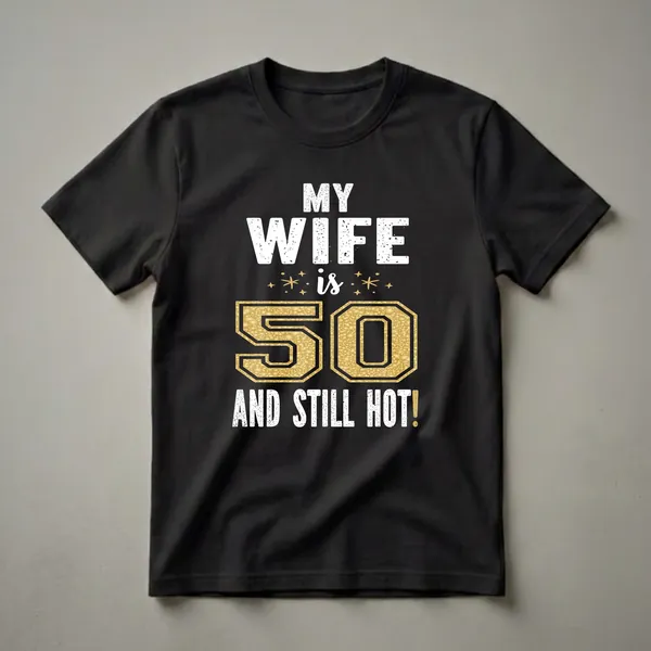 Black t-shirt with white distressed text reading 'MY WIFE is 50 AND STILL HOT!' and a large gold glittery number 50.