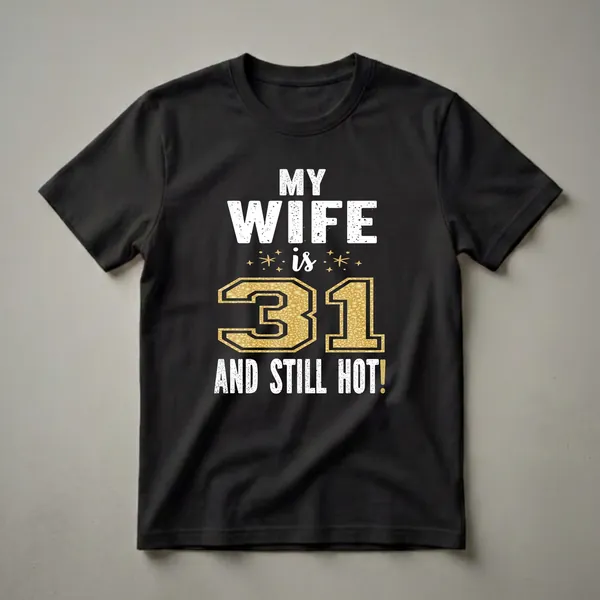 Black t-shirt with white distressed text reading 'MY WIFE is 31 AND STILL HOT!' with a large glittery gold number 31 in the center and small gold star accents.
