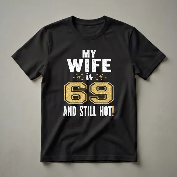 Black t-shirt with white distressed text 'MY WIFE is 69 AND STILL HOT!' and a large gold textured number 69.