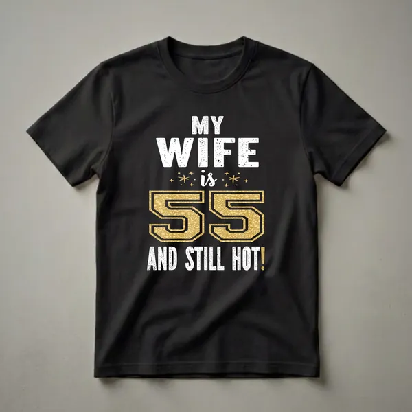 Black t-shirt with white distressed text reading "MY WIFE is 55 AND STILL HOT!" with a large gold glitter-filled number 55 and small gold starbursts.