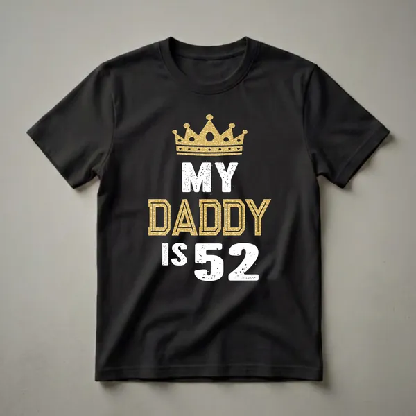 Black t-shirt with white distressed text 'MY DADDY IS 52' and a gold glittery crown above the word 'MY'. The word 'DADDY' is in gold with a textured fill.