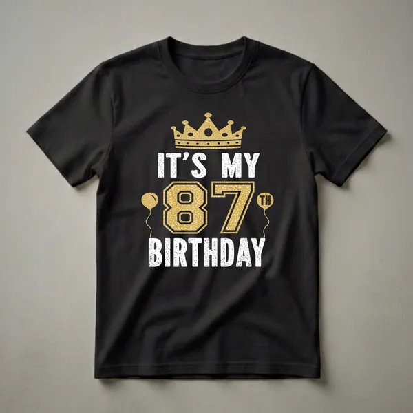 Black t-shirt with white distressed text reading 'IT'S MY 87TH BIRTHDAY' and a large gold '87' with a gold crown and two gold balloons.