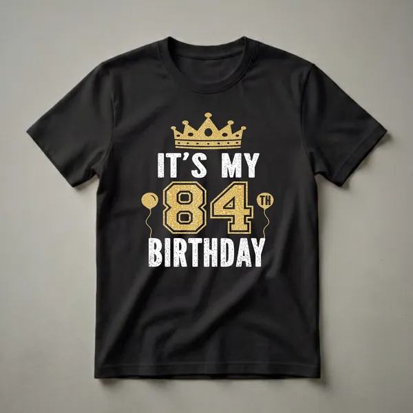 Black t-shirt with a golden crown, golden balloons, and the text 'IT'S MY 84TH BIRTHDAY' in distressed white and textured gold lettering.