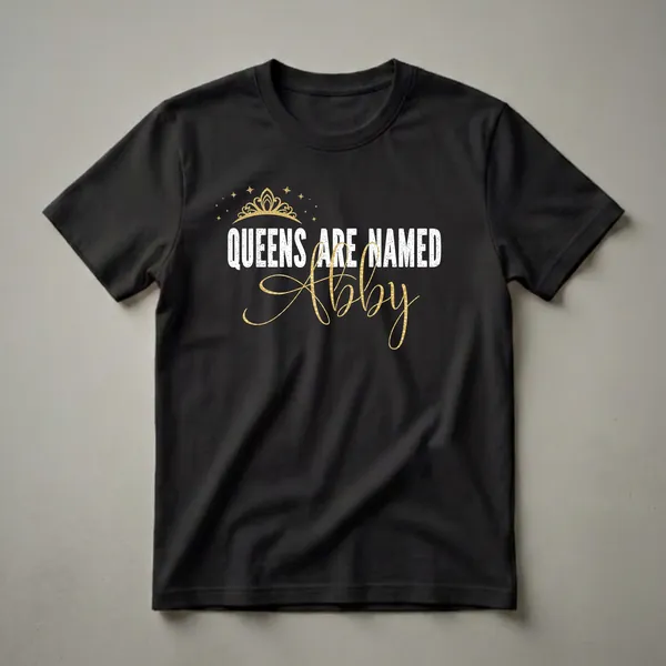 Black t-shirt with white distressed text 'QUEENS ARE NAMED' and gold script text 'Abby', topped with a golden crown and scattered gold stars.