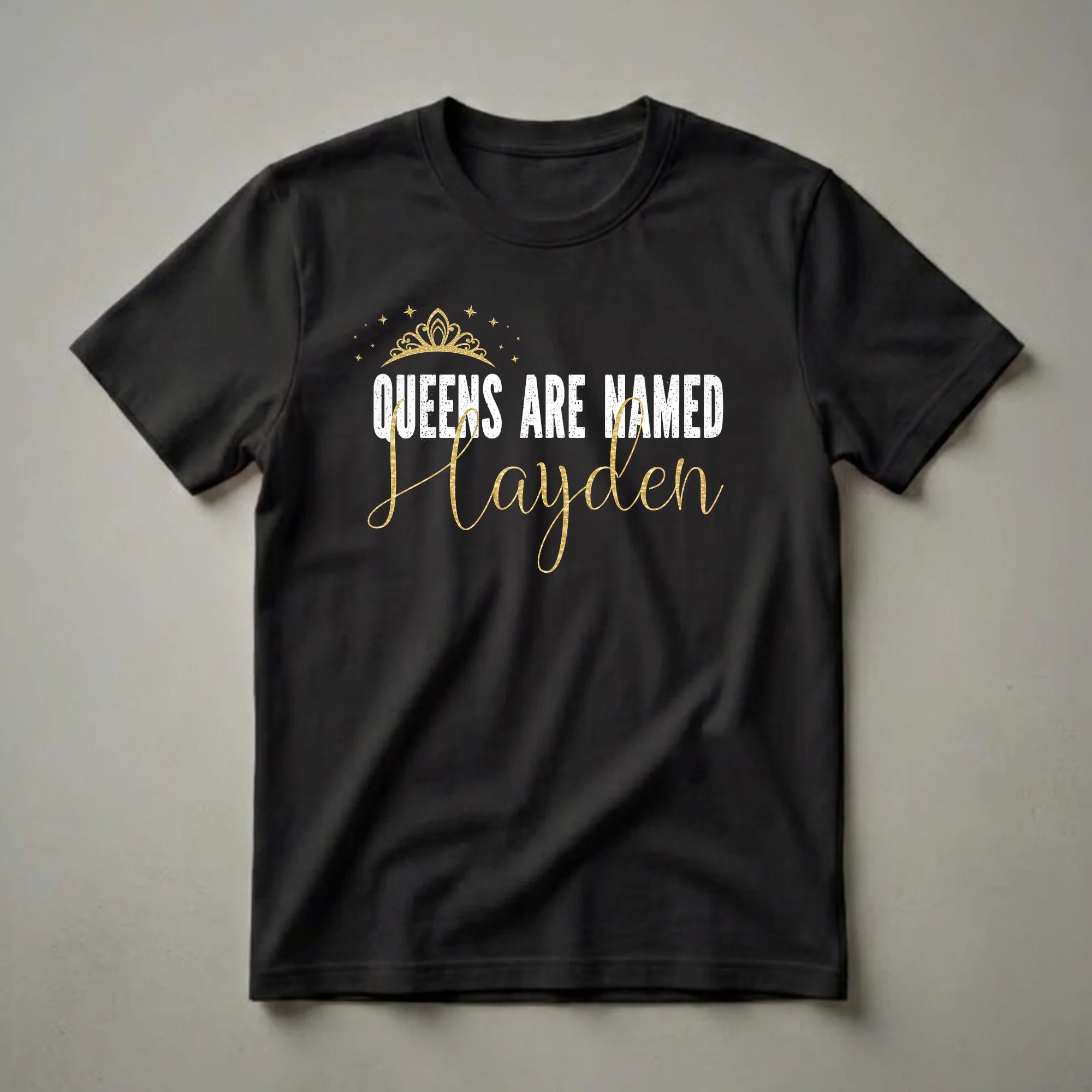 Black t-shirt with white distressed text 'QUEENS ARE NAMED' above a gold script name 'Hayden', accented with a gold crown and stars.