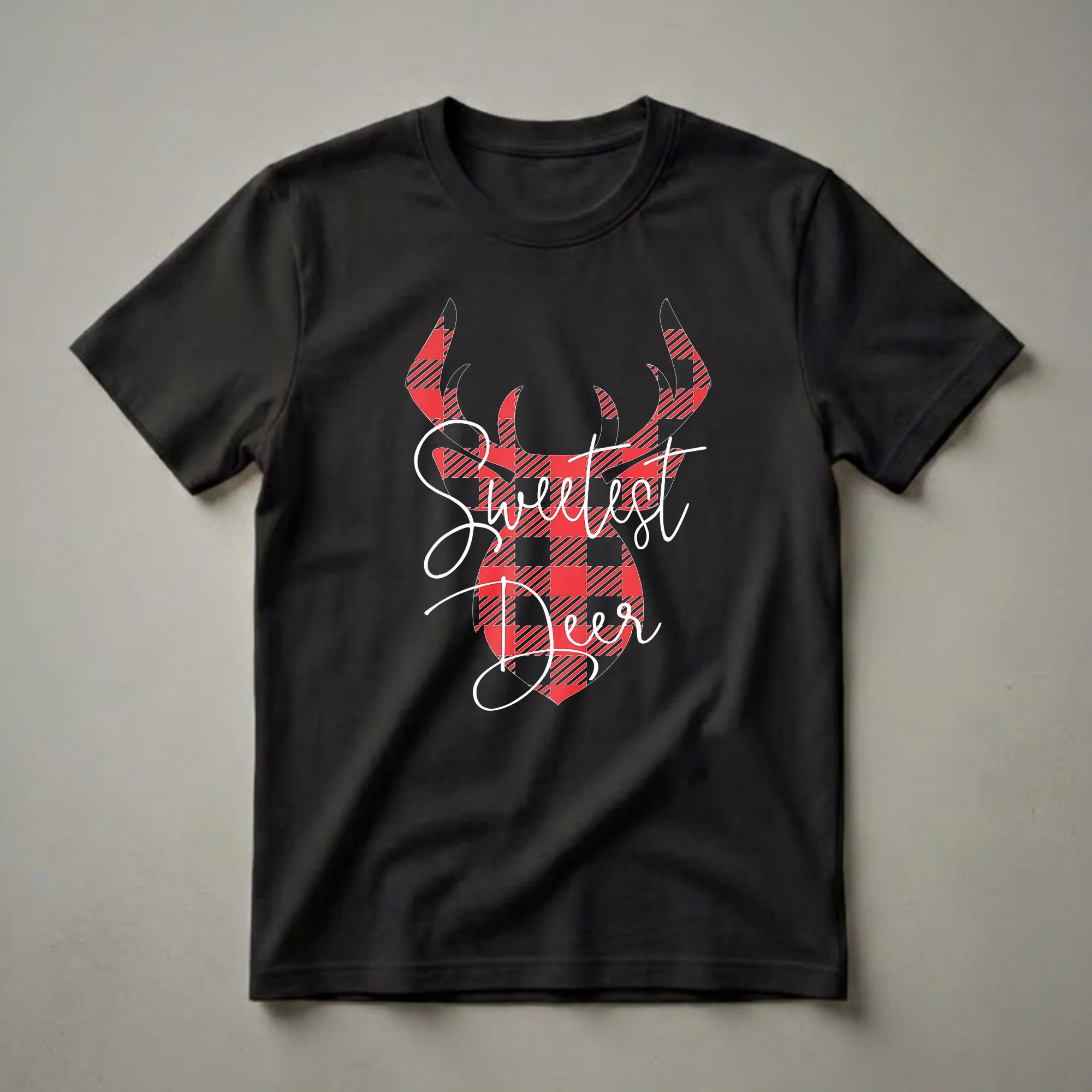 A black t-shirt featuring a deer head graphic with antlers, filled with a red and black buffalo plaid pattern, and white cursive text that reads 'Sweetest Deer'.