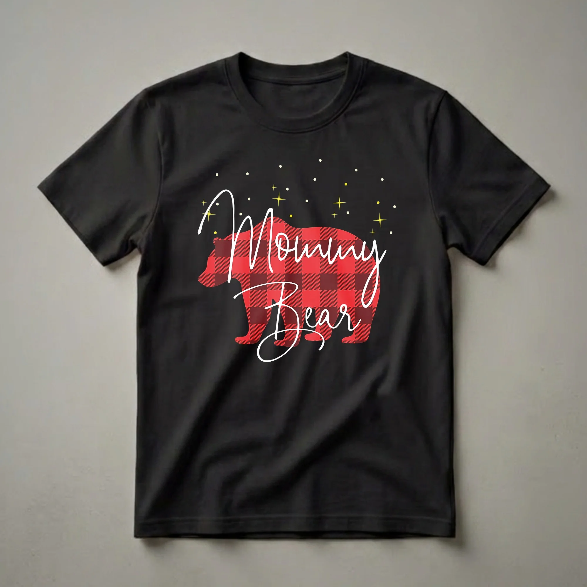 Black t-shirt with a red and black buffalo plaid bear graphic and white cursive text that reads 'Mommy Bear', with yellow stars and white dots.