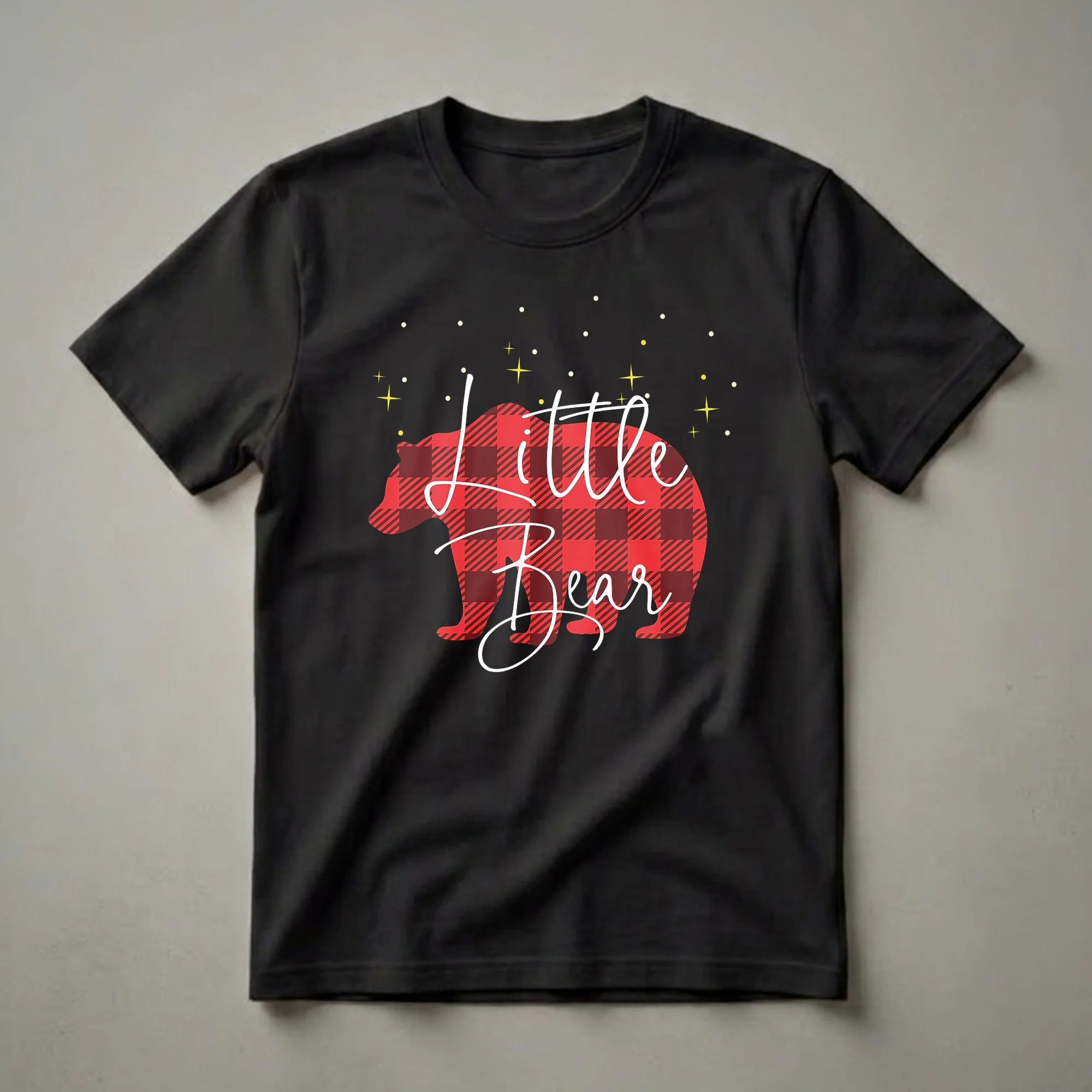 Black t-shirt with a red and black buffalo plaid bear silhouette and white cursive text 'Little Bear', with yellow stars and white dots on a black background.