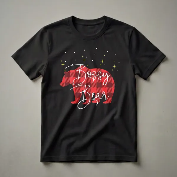 Black t-shirt with a red and black buffalo plaid bear silhouette and white cursive text reading 'Bossy Bear', set against a black background with yellow stars and white dots.