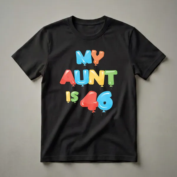A black t-shirt with the text 'MY AUNT IS 46' written in colorful, inflated balloon letters, including blue, orange, red, yellow, and green.