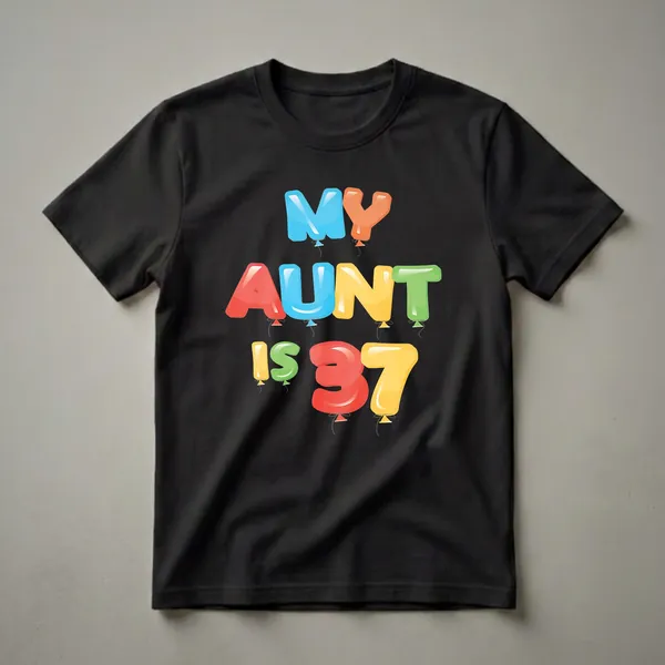 A black t-shirt featuring the phrase 'MY AUNT IS 37' in colorful, inflated balloon letters with strings.