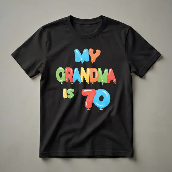 Black t-shirt with colorful balloon letters spelling 'MY GRANDMA IS 70', with blue, orange, green, red, and yellow balloons.