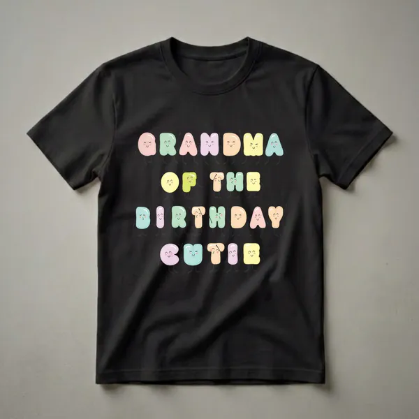 Black t-shirt with the words "Grandma Of The Birthday Cutie" written in colorful, kawaii-style letters with cute faces and arms and legs.