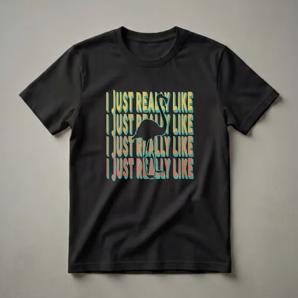 Black t-shirt with a graphic design featuring the phrase 'I JUST REALLY LIKE' repeated in yellow and orange, with a black flamingo silhouette in the center.