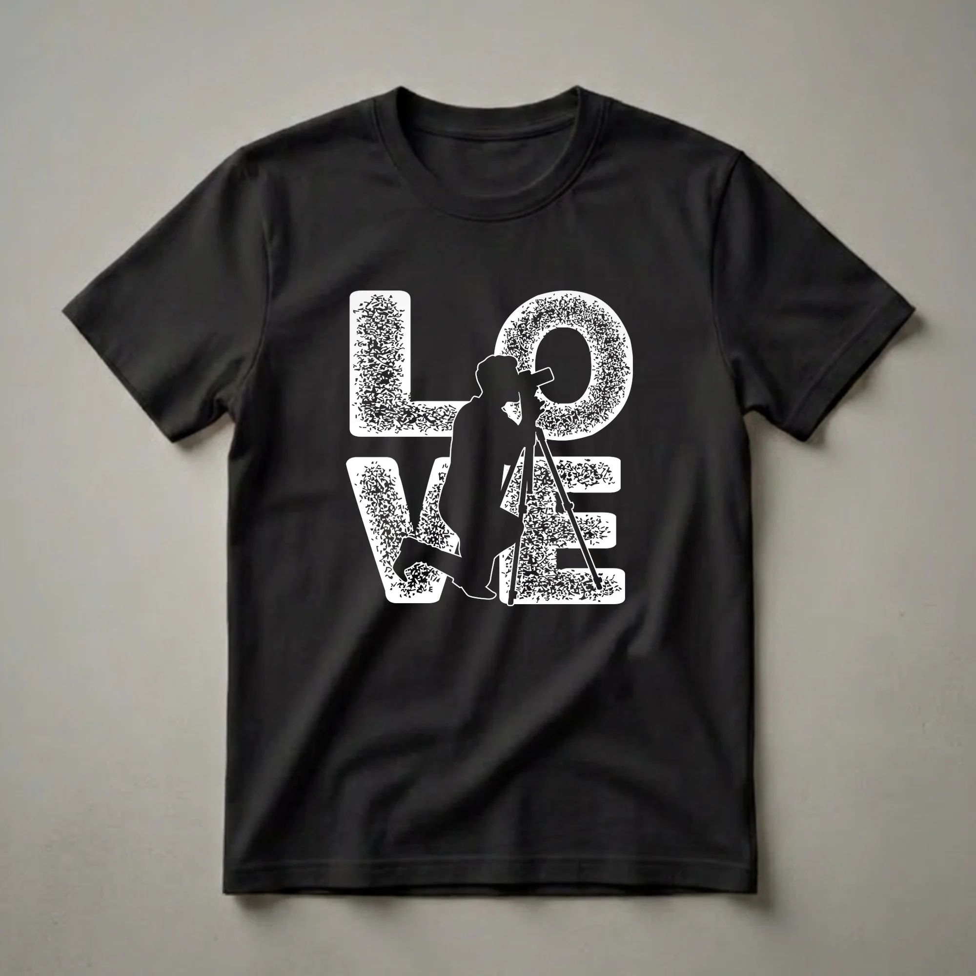 Black t-shirt with a white graphic design that spells out "LOVE", with the letter 'O' formed by a silhouette of a photographer kneeling with a camera on a tripod.