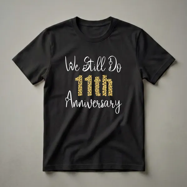 Black t-shirt with white script text 'We Still Do' and 'Anniversary', with the number '11th' displayed in gold glitter circles.