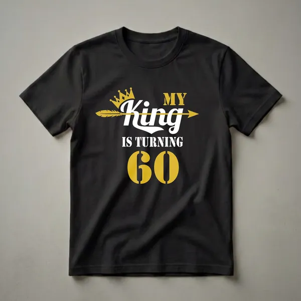 Black t-shirt with gold and white text that reads 'MY KING IS TURNING 60' with a gold crown and arrow graphic.