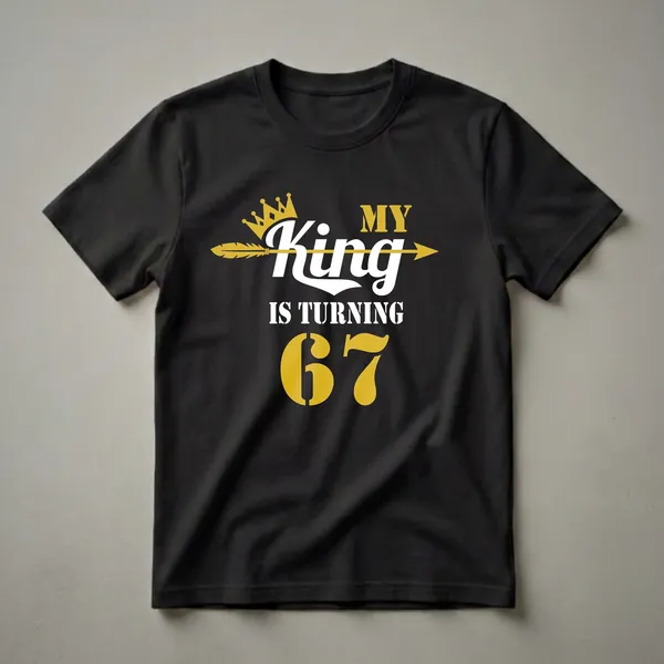 Black t-shirt with gold and white text that reads "MY King IS TURNING 67" with a gold crown and arrow graphic.